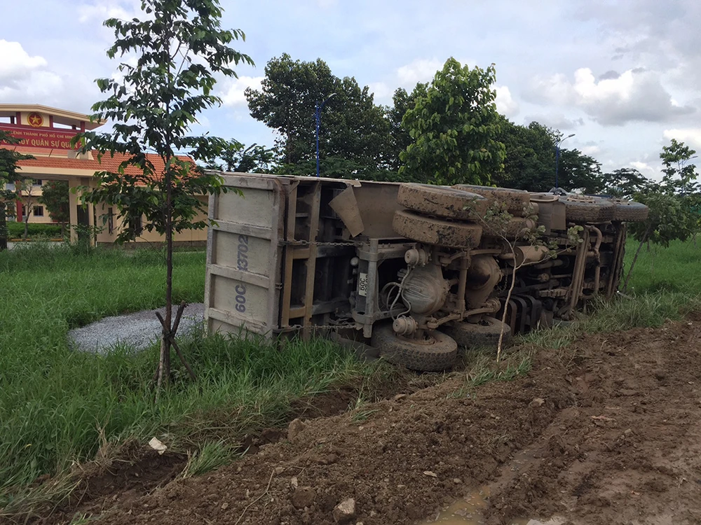 Chiếc xe tải lật nhào xuống đường, toàn bộ đá dăm xây dựng tràn ra ngoài. 